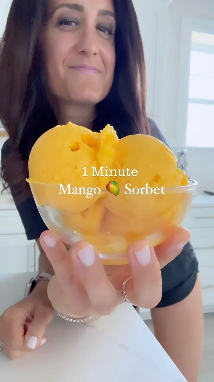 A bowl of creamy 1-ingredient mango sorbet topped with fresh mango slices.