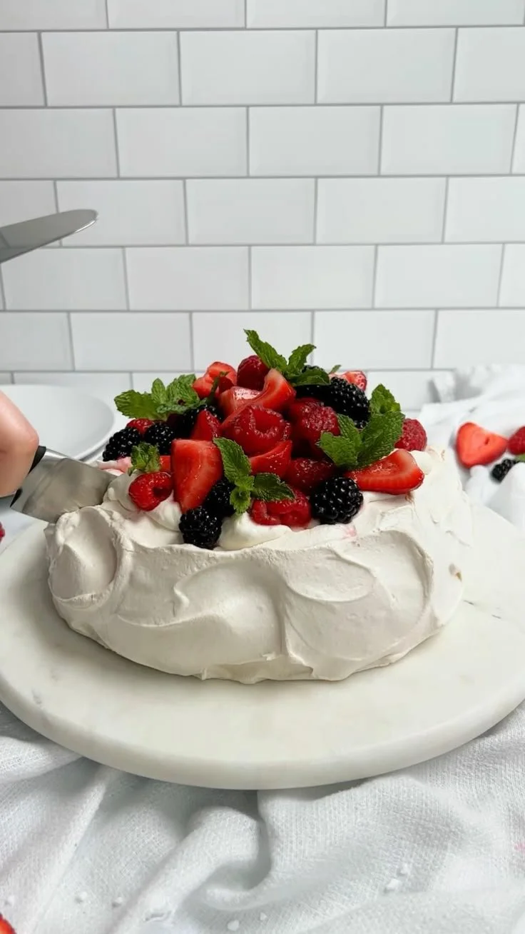 Delicious Berry Pavlova topped with fresh berries and whipped cream