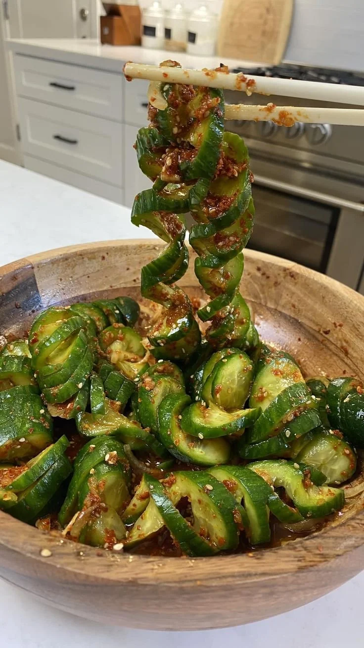 Fresh cucumber salad with tomatoes, onions, and herbs served in a bowl.
